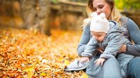 Happy family outdoors. Mother and her little daughter play cuddling on autumn walk in nature outdoors