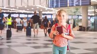 Little preschool girl at airport terminal. Happy child going on vacations by airplane. Smiling kid with passport and bag.