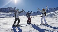 Mother and teenage kids skiing together at a glacier ski resort in the Alps mountains on a sunny winter day