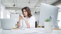 Worried businesswoman using mobile phone in office