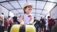 Cheerful and excited toddler with her coffer on a airport