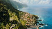 Aerial View of Coastal Road to Town Surrounded by Ocean and Mountains