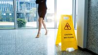 Caution wet floor sign with motion blurred legs walking