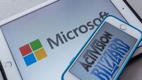 Microsoft and Activision Blizzard logos on smartphone and tablet. Microsoft announced that they are planning to purchase Activis