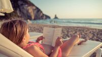 Girls relaxing on the beach and reading a book