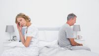 Annoyed couple sitting on different sides of bed