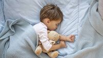 Photo of baby boy sleeping together with teddy bear.